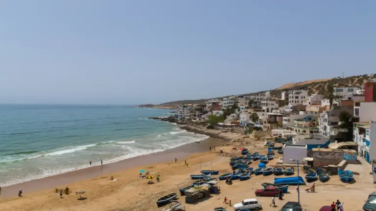 Playa de Essaouira al atardecer con cometas de kitesurf sobre el Atlántico